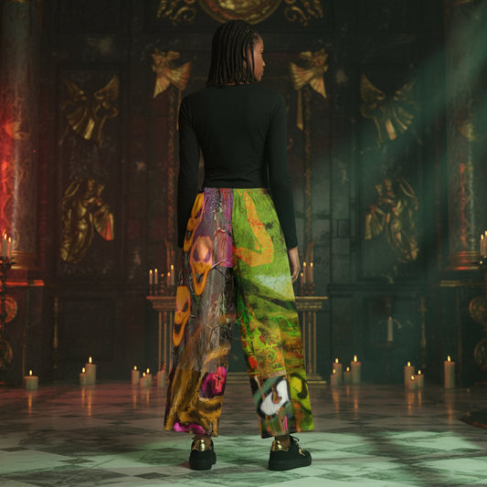 A person stands with their back to the camera in a dark, ornate room with candles, wearing a black long-sleeve top and wide-leg pants featuring a vibrant, multicolored abstract print.