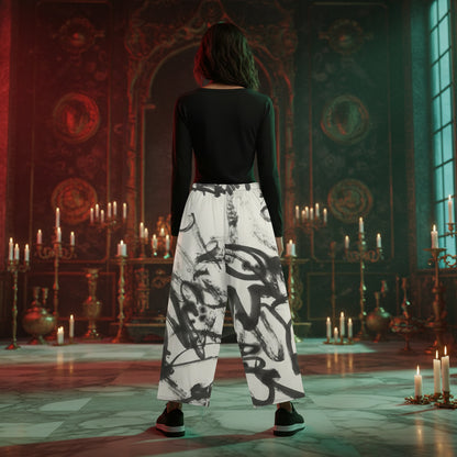 A person stands with their back to the camera in an ornate, candle-lit room, wearing a fitted black long-sleeve top and wide-leg white pants with a bold black abstract brushstroke pattern.