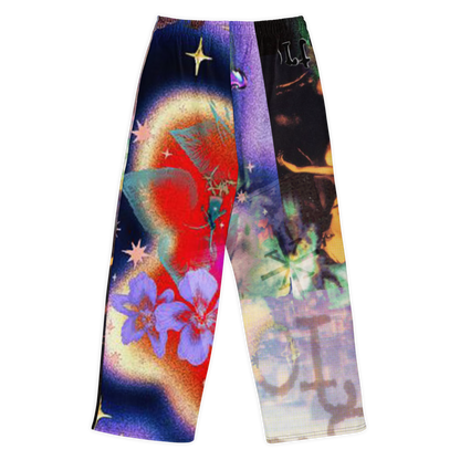 A pair of wide-leg pants featuring a highly vibrant, split-color psychedelic print. The left leg displays a cosmic scene with a red sun, purple flowers, and blue nebulae, while the right leg features a dark space background with a large anchor and colorful celestial elements.