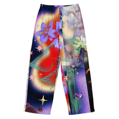 A pair of wide-leg pants featuring a vibrant, psychedelic abstract print with a large purple flower, red and yellow celestial shapes, green cactus-like forms, and star details on a white background.